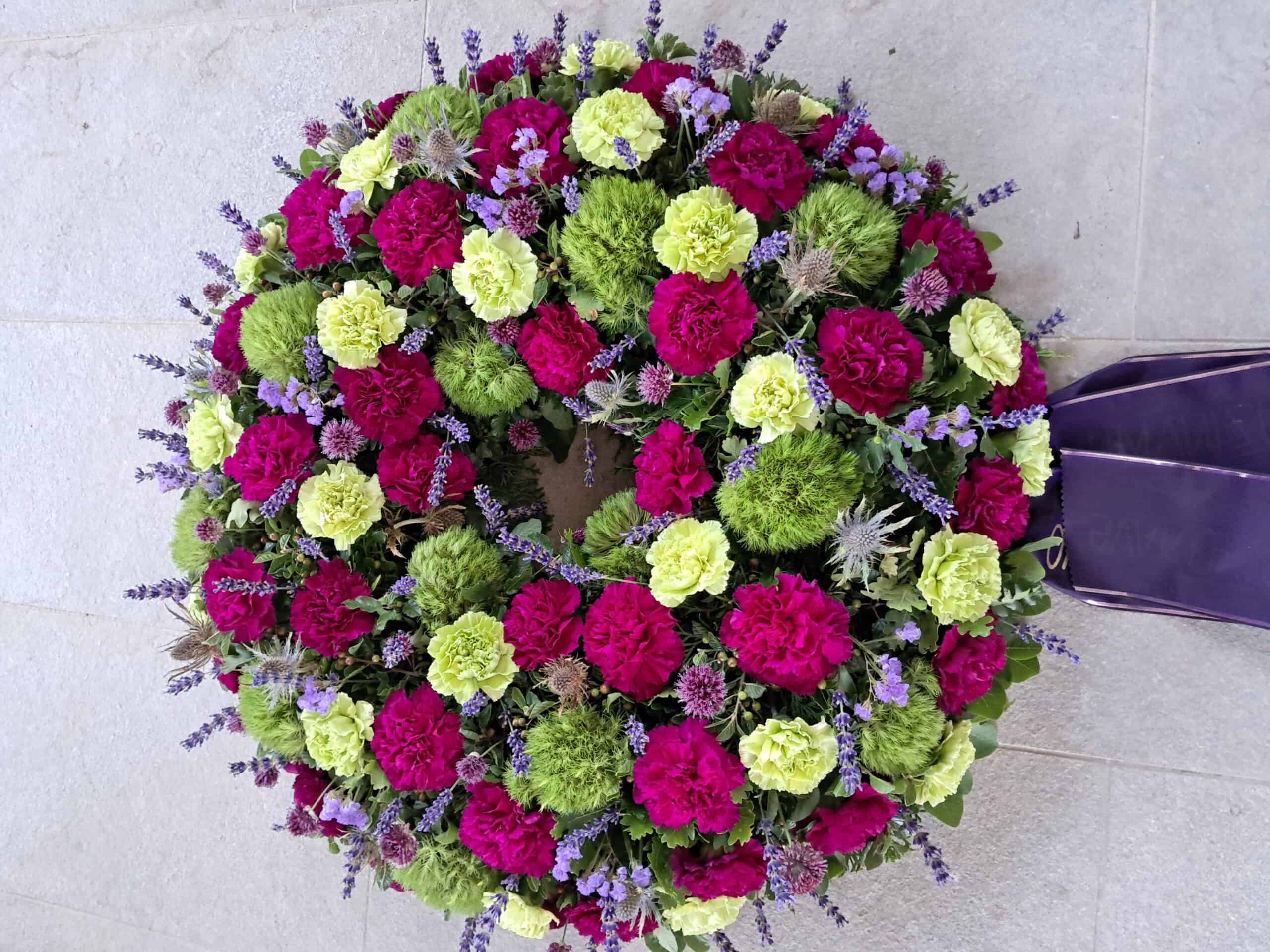 Barvito okrašena poročna venec iz hortenzij, sivke in drugih cvetlic, ustvarjen za posebne dogodke in dekoracijo.